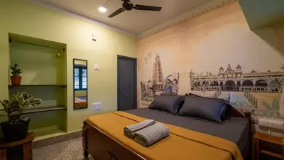 a bedroom with a bed with a painting on the wall at Trippr Mysuru in Mysore