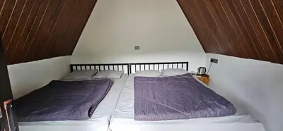 a small bedroom with two beds with purple blankets at The Soul Of Vattavada in Vattavada