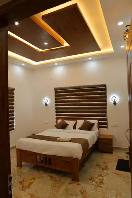 a bedroom with a large bed with a wooden headboard at Josebaa Inn in Vythiri