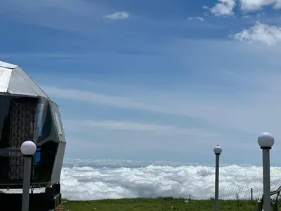 a building on top of a mountain above the clouds at Kodaikanal Luxuries Glamp - Krishna Paradize in Kūkkāl