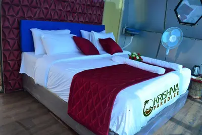 a large bed with white sheets and red pillows at Kodaikanal Luxuries Glamp - Krishna Paradize in Kūkkāl