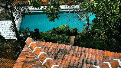 a brick wall next to a swimming pool at Churuli Bungalow in Ambalavayal