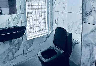 a bathroom with a sink and a toilet and a window at Churuli Bungalow in Ambalavayal