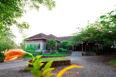 a house with a yard with a house at The Hidden Pearl Palakkad by Chakolas Hospitality in Thenkurissi