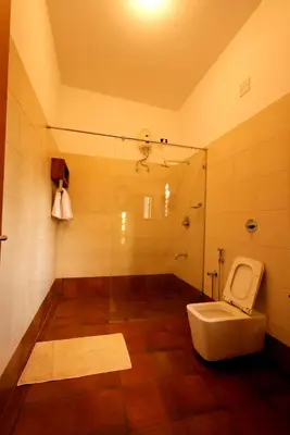 a bathroom with a toilet and a shower at The Hidden Pearl Palakkad by Chakolas Hospitality in Thenkurissi