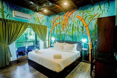 a bedroom with a bed with a mural of bamboo at Falcon Riverview Resorts in Kuttampuzha