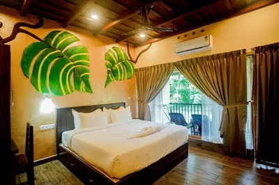 a bedroom with a bed in a room with a window at Falcon Riverview Resorts in Kuttampuzha
