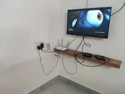 a room with a tv on a wall with wires at Nandan Elite in Mysore