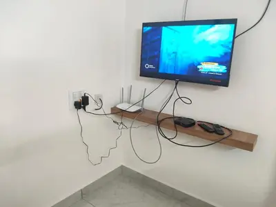 a flat screen tv hanging on a white wall at Nandan Elite in Mysore