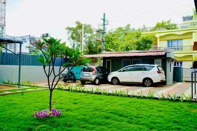 two cars parked in a yard next to a house at Elite Enclave - Mysore - 2BHK Luxury Serviced Apartments in Mysore