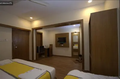 a hotel room with two beds and a television at Hotel president park Coimbatore in Coimbatore