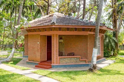 a small brick house in a yard with trees at Kairali - The Ayurvedic Healing Village in Palakkad