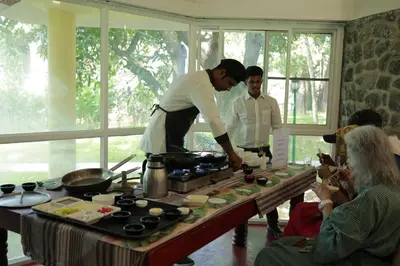 a man standing in a kitchen preparing food at Kairali - The Ayurvedic Healing Village in Palakkad