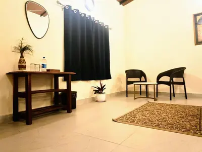 a room with a table and chairs and a mirror at The Road's End in Gonikoppal