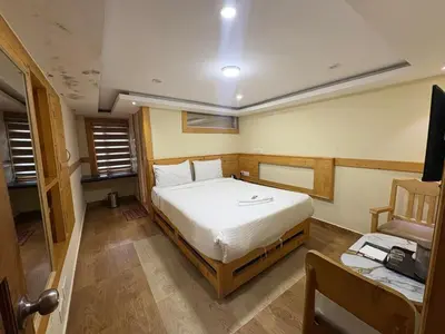 a small bedroom with a bed and a chair at Rozana Retreats Ooty in Ooty