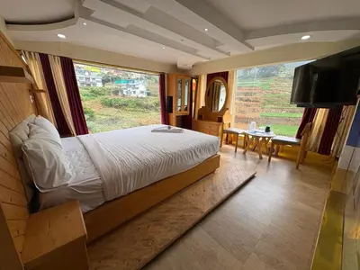 a bedroom with a large bed and a large window at Rozana Retreats Ooty in Ooty