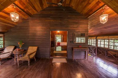 a living room with wooden walls and a ceiling with wood floors at Pepper Trail in Sultan Bathery
