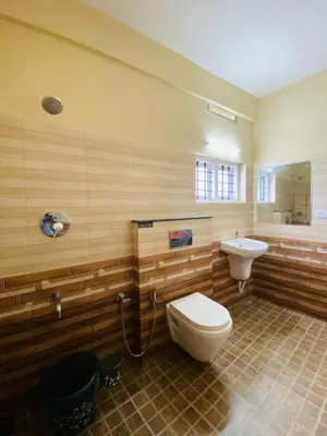 a bathroom with a toilet and a sink at O'live Inn Wayanad Apart-Hotels in Vaduvanchal