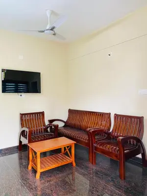a living room with two leather couches and a coffee table at O'live Inn Wayanad Apart-Hotels in Vaduvanchal