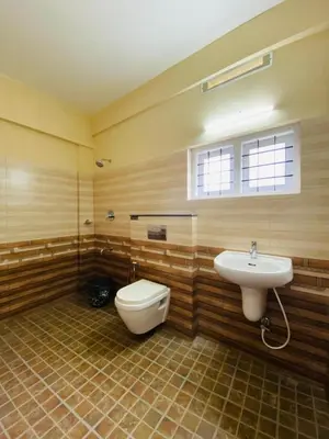 a bathroom with a toilet and a sink at O'live Inn Wayanad Apart-Hotels in Vaduvanchal