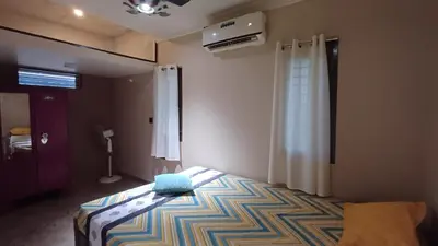 a bedroom with a bed with a blue pillow on it at SHI's Thulasi 2BHK in Coimbatore Near to Karpagam College, Palakkad Highway, Rathinam College and More in Coimbatore