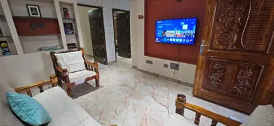 a living room with a couch and a flat screen tv at SHI's Thulasi 2BHK in Coimbatore Near to Karpagam College, Palakkad Highway, Rathinam College and More in Coimbatore