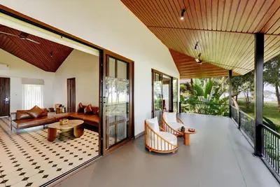 a living room with a couch and a table at Sandesh Water Edge Kabini in Begūr
