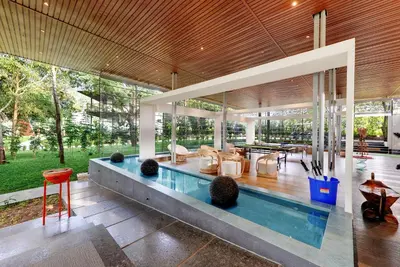 a house with a pool in the middle of it at Sandesh Water Edge Kabini in Begūr