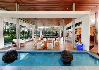 a house with a swimming pool and a living room at Sandesh Water Edge Kabini in Begūr