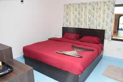 a bedroom with a large bed with red sheets and two fish on it at Rosewood 1 in Ooty