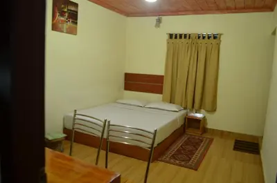 a small bedroom with a bed and a curtain at Rheinberg Town Haus in Munnar