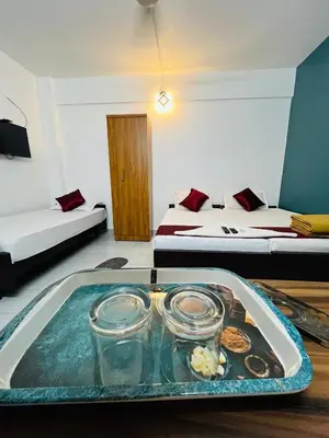 a tray of food on a table in a room with two beds at Priya lodge in Kozhikode
