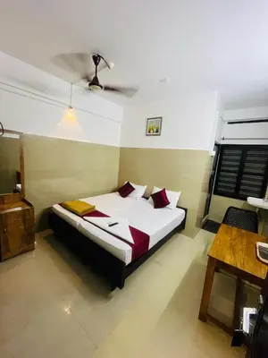a bedroom with a bed and a ceiling at Priya lodge in Kozhikode