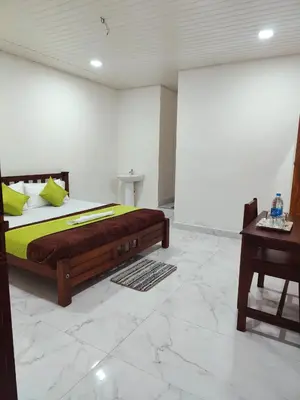 a bedroom with a large bed and a table at Chaithanya Illam in Marayoor