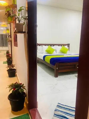 a bedroom with a bed with yellow and blue pillows at Chaithanya Illam in Marayoor