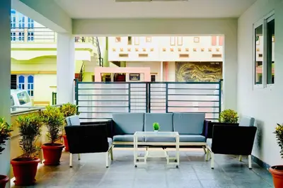a patio with a blue couch and chairs and a table at Elite Enclave - Spark - 2BHK Luxury Serviced Apartment in Mysore