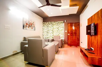 a waiting room with couches and a flat screen tv at Elite Enclave - Spark - 2BHK Luxury Serviced Apartment in Mysore