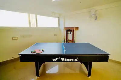 a ping pong table in a room with at Elite Enclave - Vento - 2BHK Luxury Serviced Apartments in Mysore