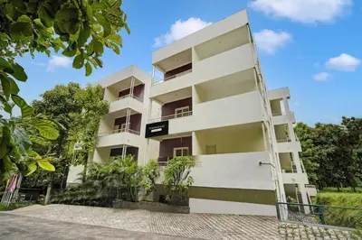 a white building with a sign on it at Super Townhouse Hebbal Mysore in Mysore