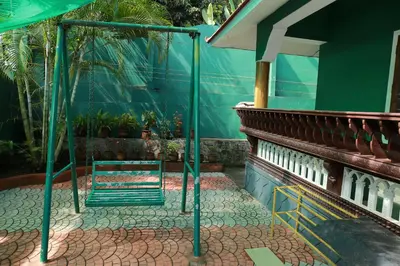 a patio with a green fence and a table at County Pep in Wayanad