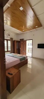 a bedroom with a large bed with a wooden ceiling at Dhara Dhvani Getaway Homes in Tindummal