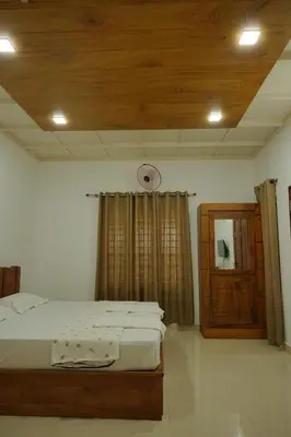 a bedroom with a bed and a wooden ceiling at Dhara Dhvani Getaway Homes in Tindummal