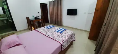 a bedroom with a bed with a blanket on it at Dhara Dhvani Getaway Homes in Tindummal