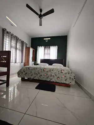 a bedroom with a bed and a ceiling fan at Bro Code Marayoor A Premium Family Friendly Retreat with Panoramic Mountain Views in Marayoor