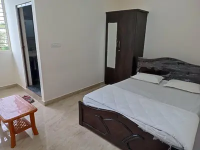 a bedroom with a large bed with a wooden headboard at Govinda Krishna Comforts in Mysore