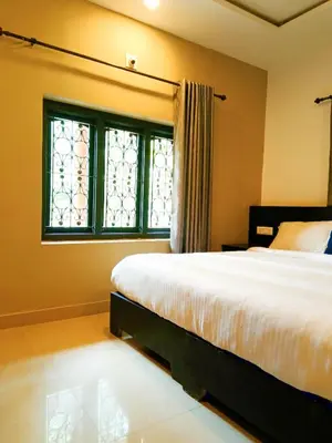 a bedroom with a bed and a window at JUNGLE VALLEY AYURVEDIC SPa RESORT in Meppādi
