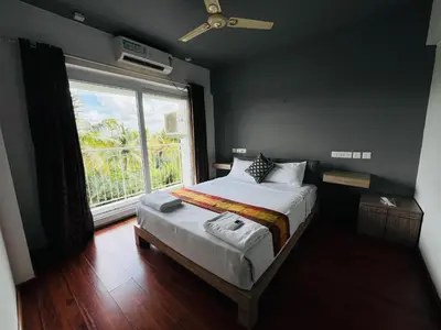 a bedroom with a bed and a large window at Transit suites by Habitat in Cochin