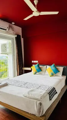 a bedroom with a bed with a red wall at Transit suites by Habitat in Cochin