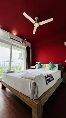 a bedroom with a large bed with a ceiling fan at Transit suites by Habitat in Cochin