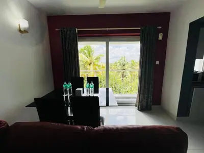 a dining room with a table and a large window at Transit suites by Habitat in Cochin
